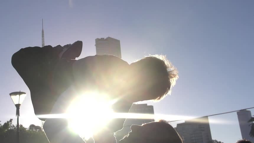 Woman lifts a young boy above her head