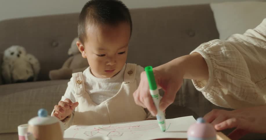 The baby is drawing with a marker