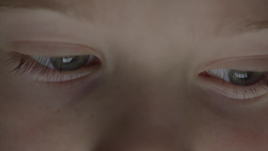 A child looking down at an electronic device