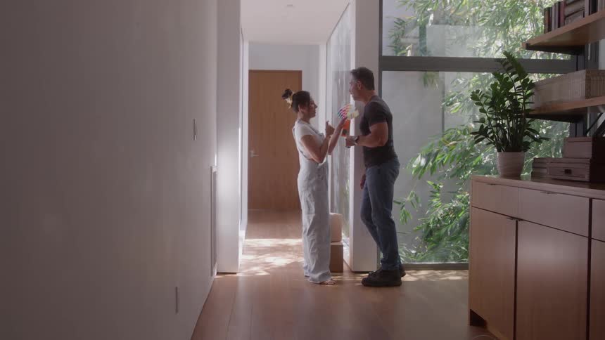 A woman showing a color palette on a piece of paper to a man