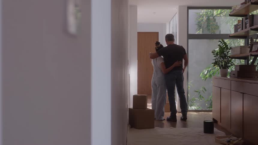 Couple hugging in a hallway with moving boxes