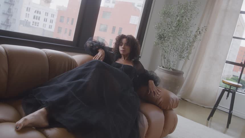 A woman lying on a couch posing