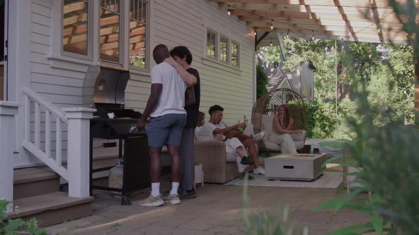 People gathered in a backyard preparing a barbecue