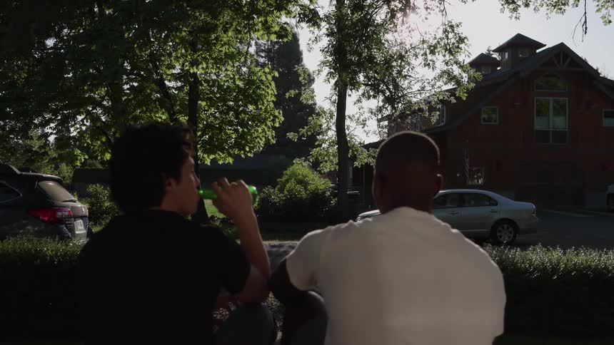 Two friends sitting outdoors talking