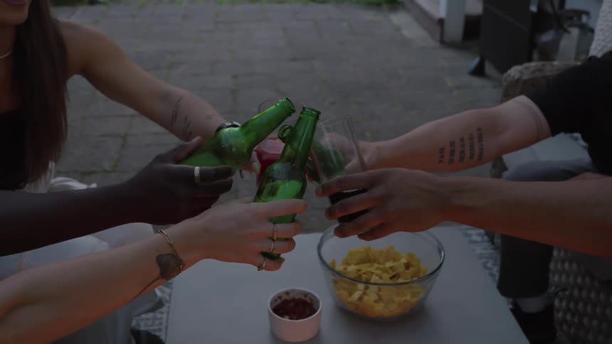 Friends toast with drinks at sunset