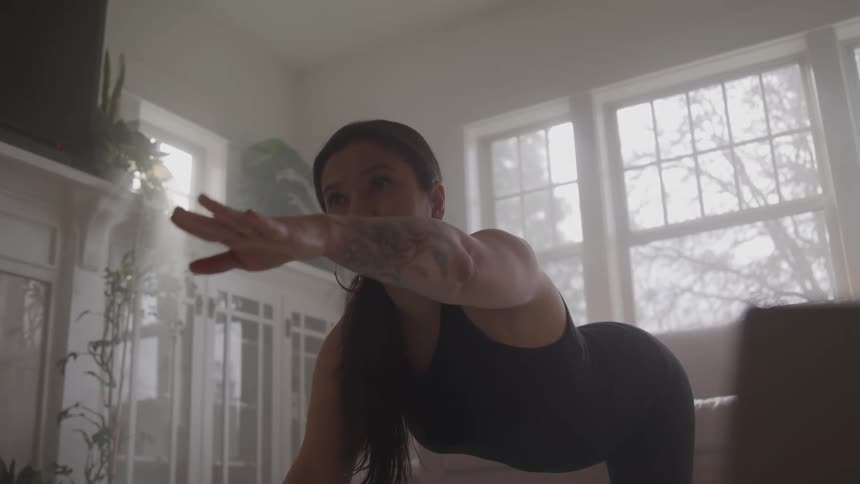 Woman practices stretching at home in the morning