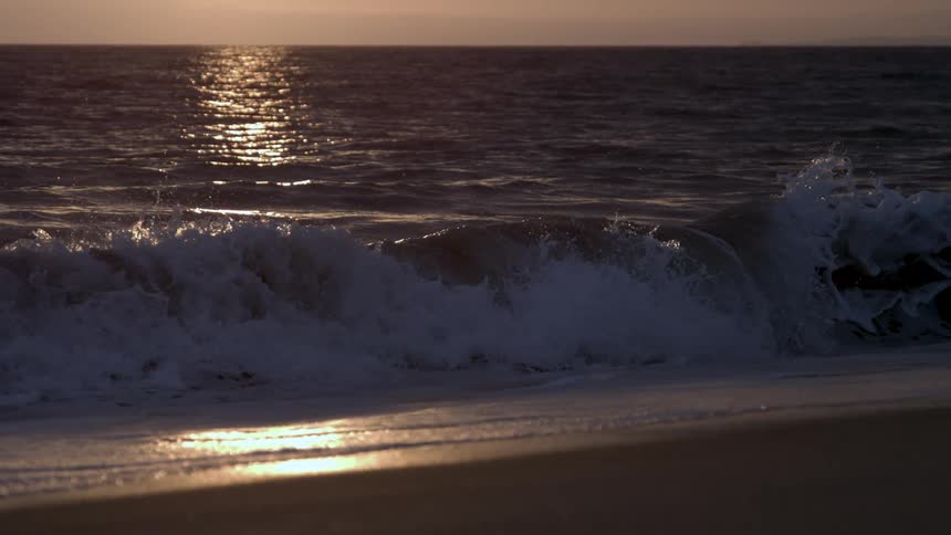 Waves roll and crash onto the sand of a beach