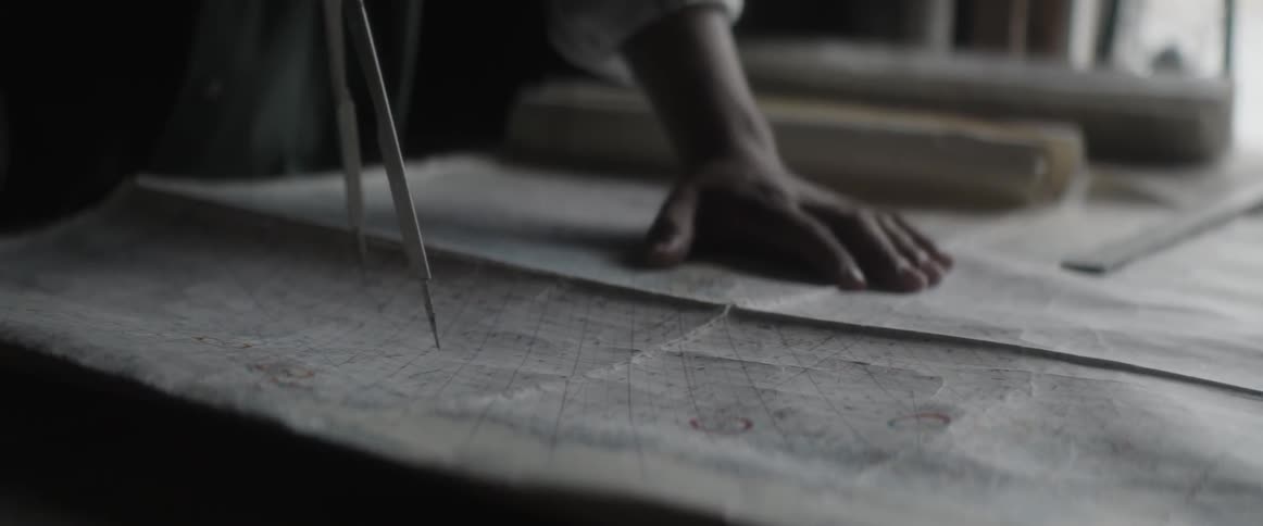 A man is using a compass on a map