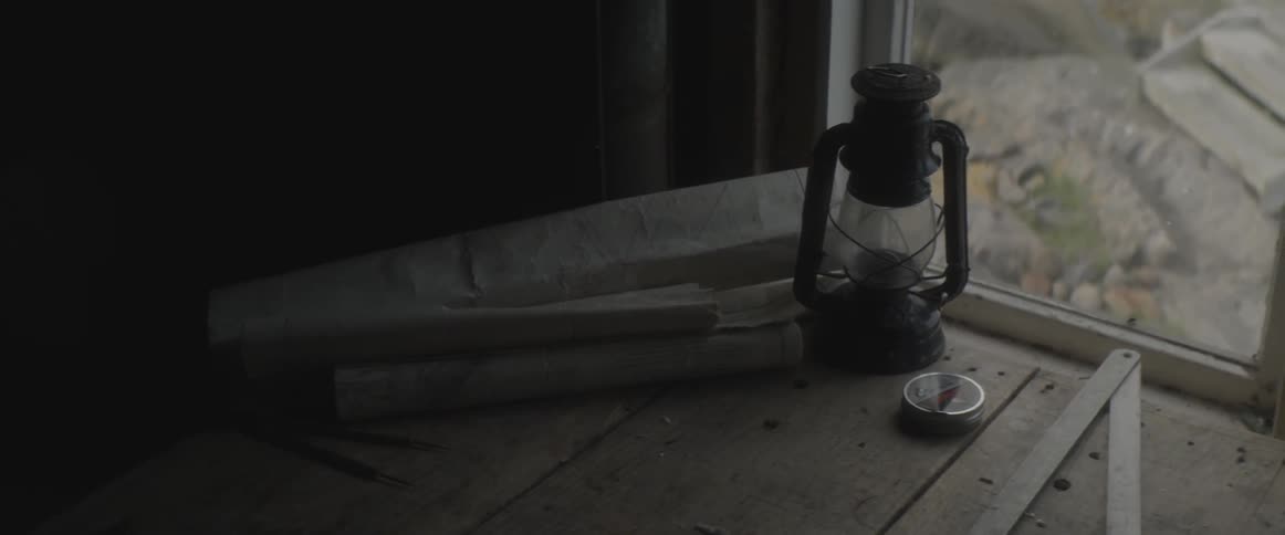 Lantern sitting next to a window on a wooden base