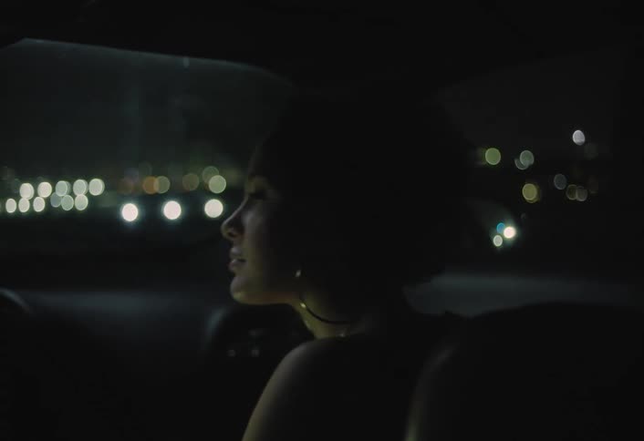 A woman riding in a car at night