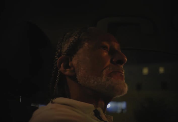 Man drives at night with a focused expression
