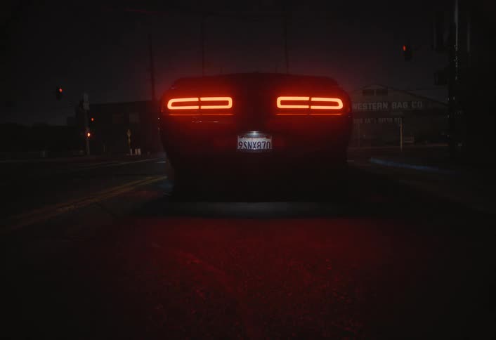 A car speeds down a quiet city street at night