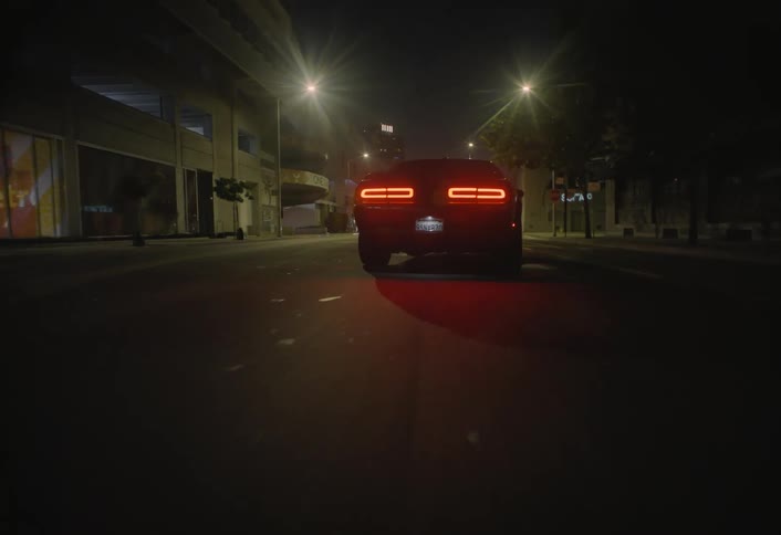 Sports car moves along a city street at night