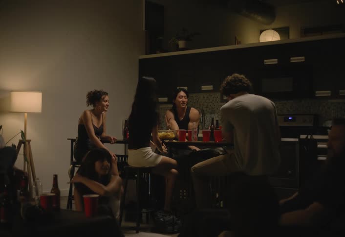 Group of friends enjoy a small party in a warmly lit kitchen