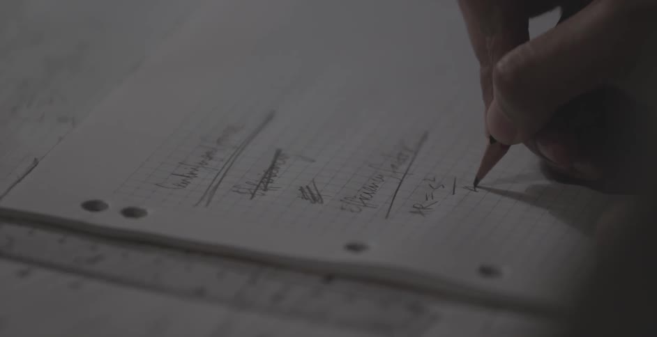 Person making notes on some lined paper