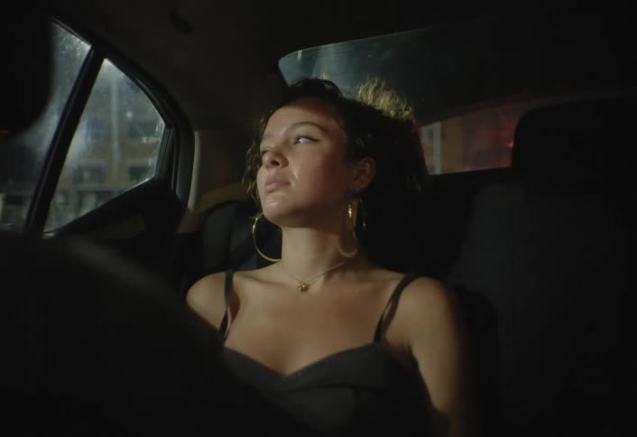 Woman sitting in the back seat of a car at night