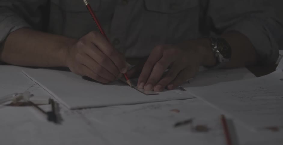 A man traces a ruler