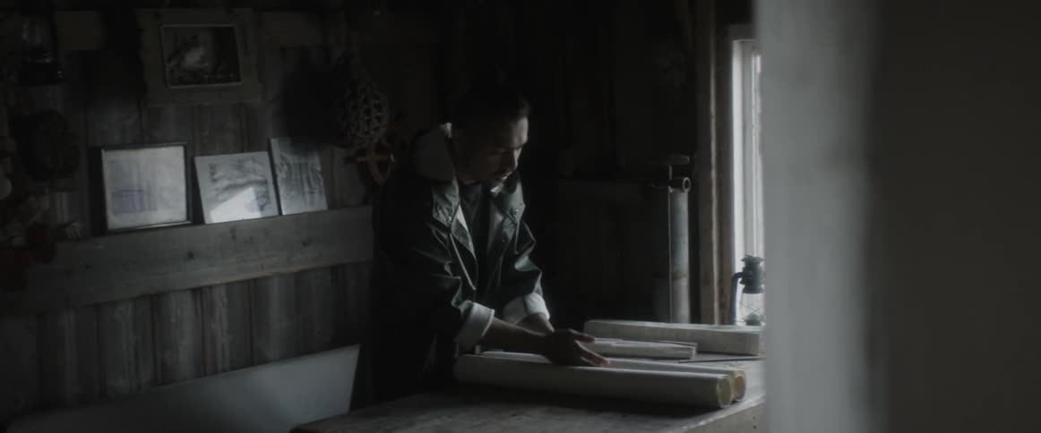 Man unrolls a map on a table