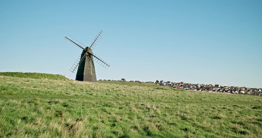 Windmill in a green field under a clear blue sky on a bright sunny day