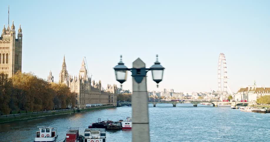 A large canal with several boats on it and a bridge crossing two parts of a city