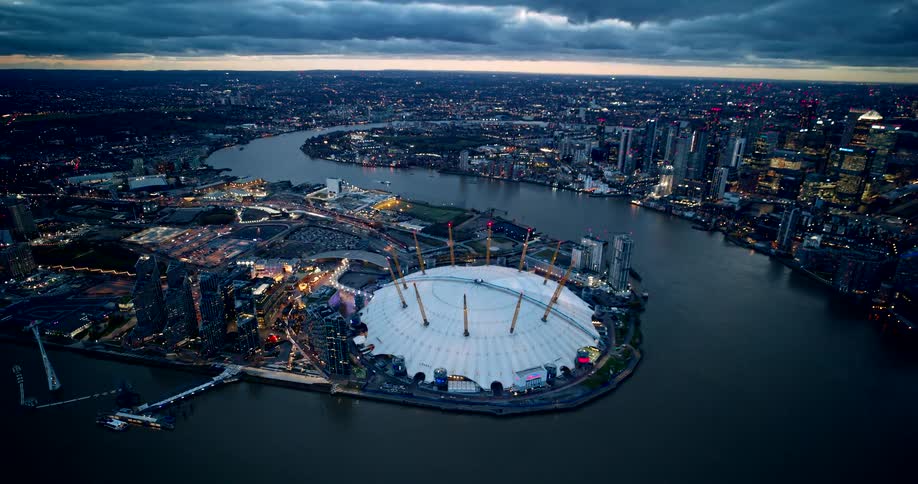 An aerial view of a whiteroofed arena next to a river that runs through the city