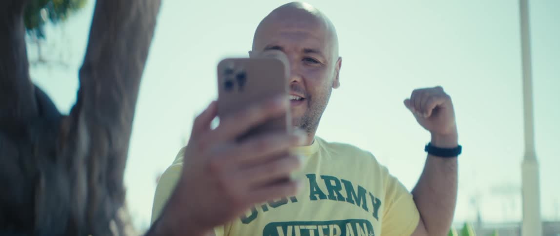 A man waves and gestures while communicating via his smartphone