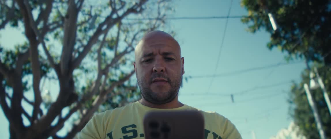 Man in a yellow shirt using a smartphone
