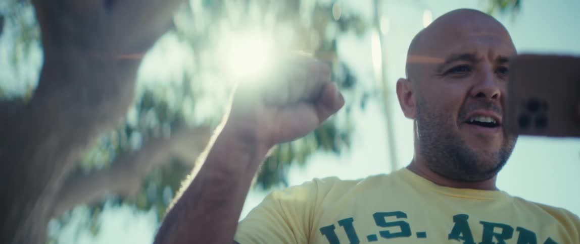 The man cheers while looking at his cell phone outside