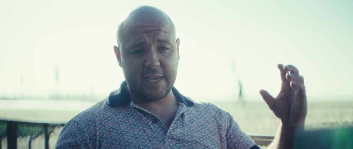 A man sitting outdoors talking