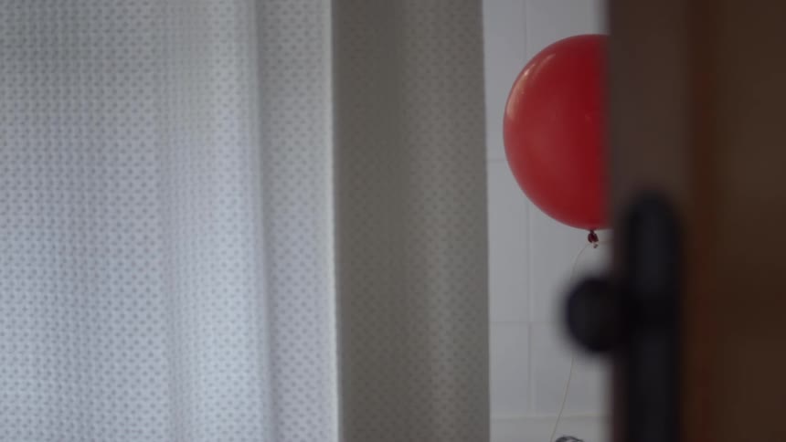 Red balloon floating inside a room