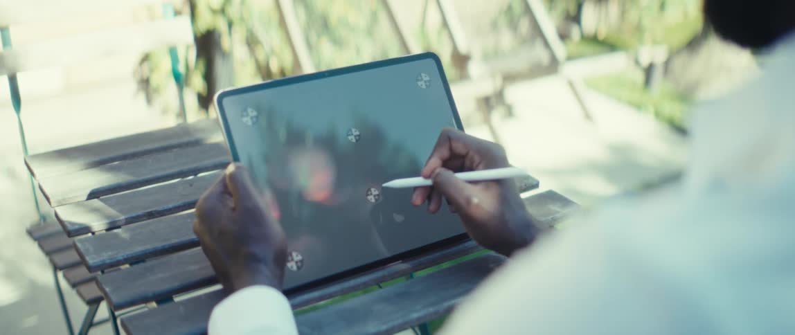 The man uses a stylus on his tablet