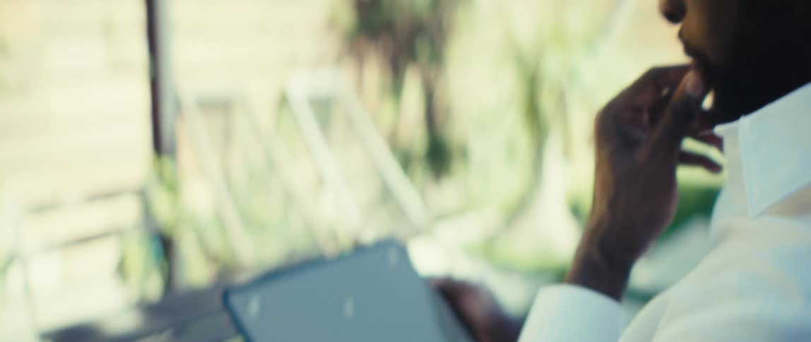 Man holds a tablet computer moving his fingers across the screen