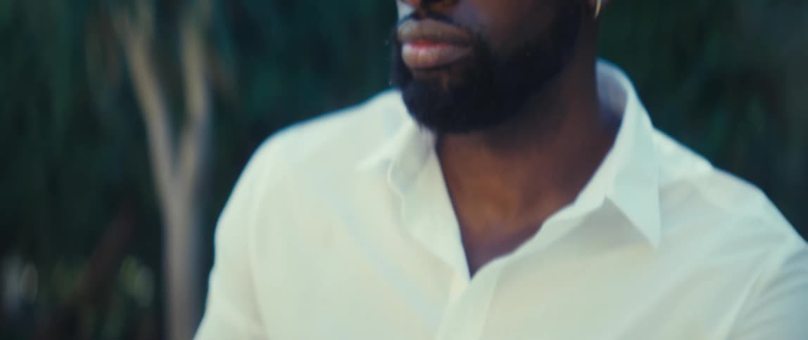 Man sits outside at a table holding his phone