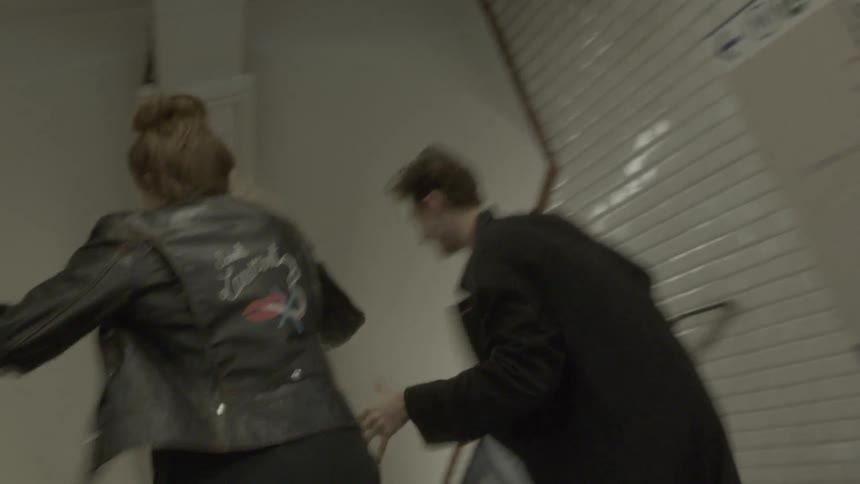 A man and woman chasing each other in a train station