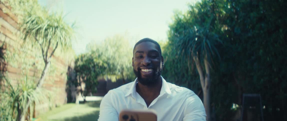 The man points around his yard while on a video call