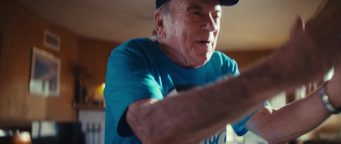 Elderly man cheering while watching tv