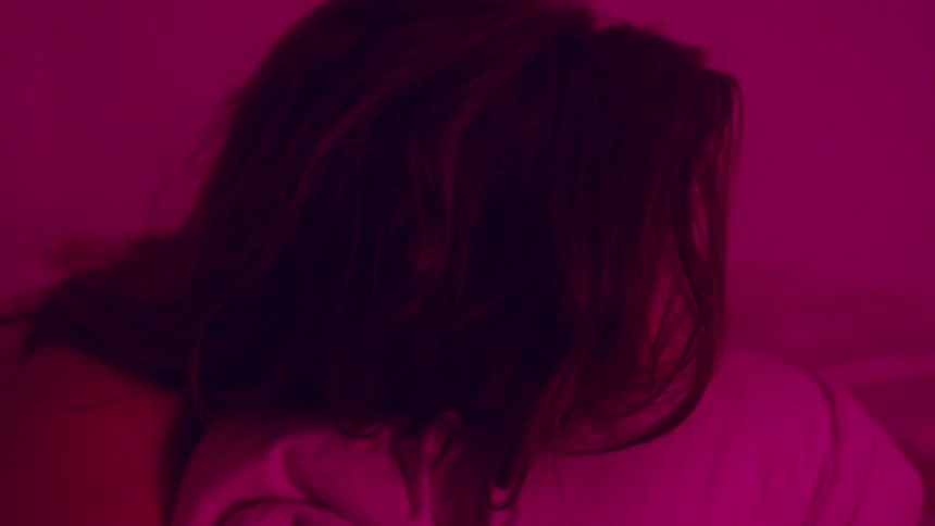 A portrait of a woman crying in a room