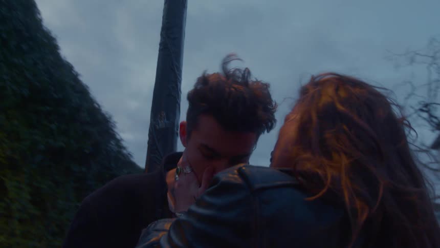 The couple are hugging by the lamp post