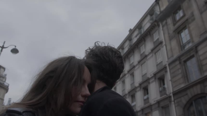 A man and woman hugging each other outdoors