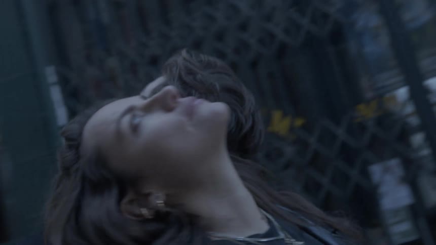 A man and woman lean against each other while look upwards