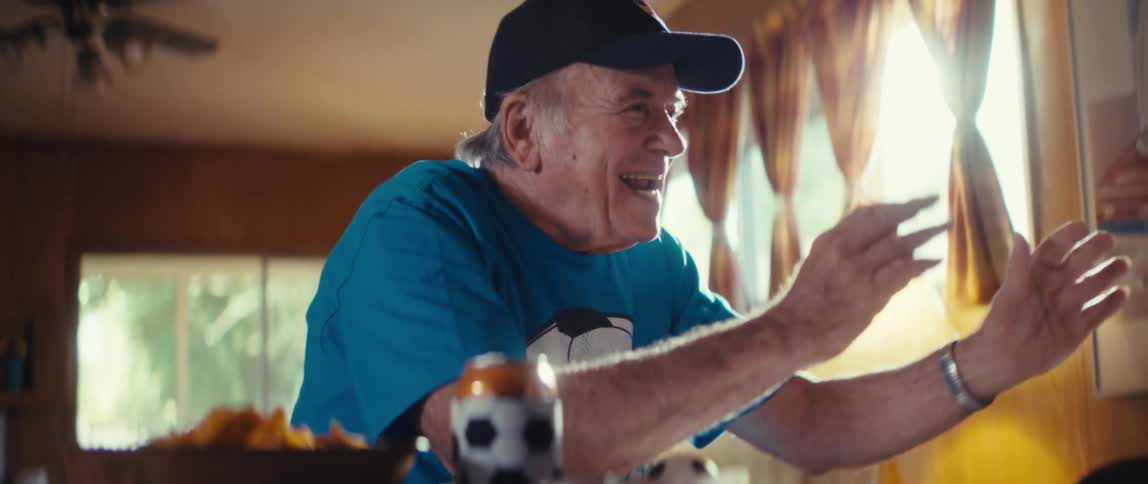 Man cheers excitedly while watching television