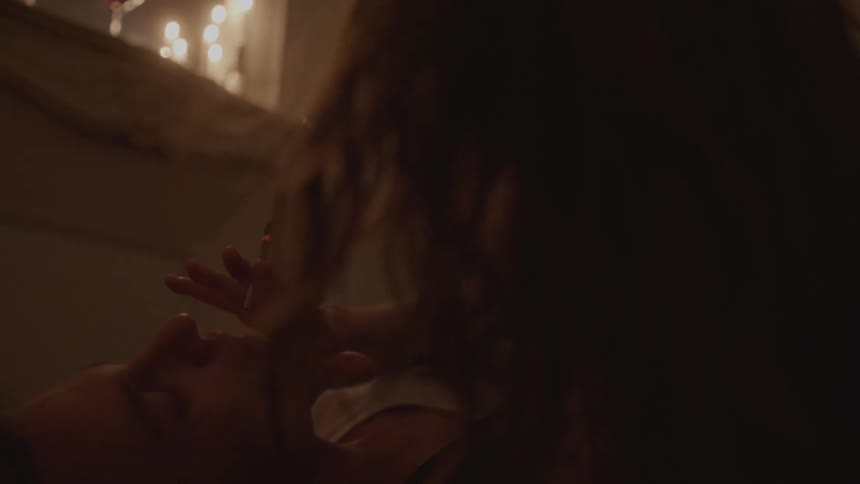 Man lying down smoking in a dimly lit room
