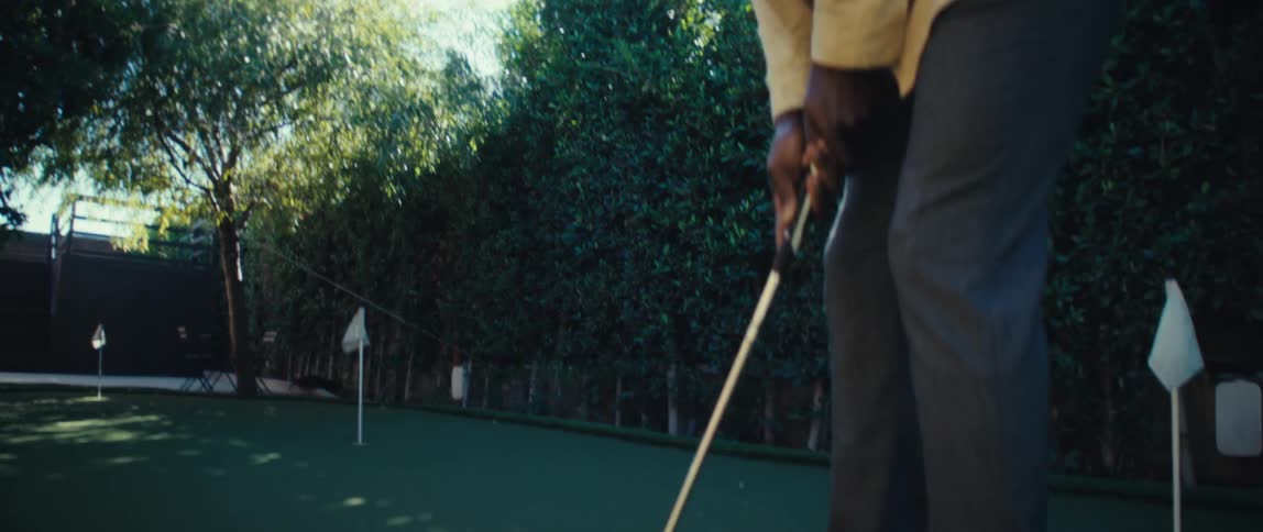 Golfer preparing to make a putt on the green