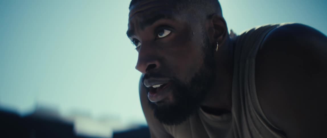A man is crouched over and breathing hard outside