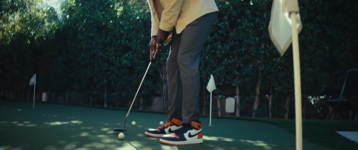 The man hits the golf ball and misses the hole