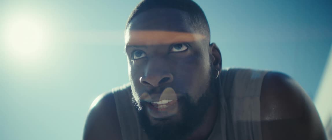A young black man catches his breath looking tired under the sun after exercising