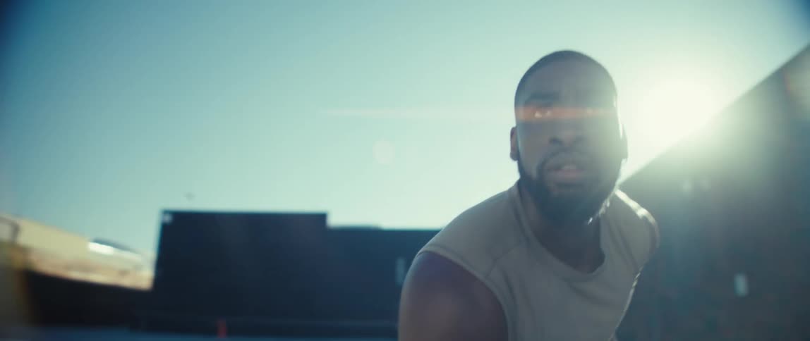 Man in an athletic stance under bright sunlight