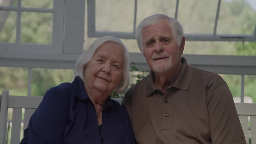 Elderly couple sitting together posing for a portrait