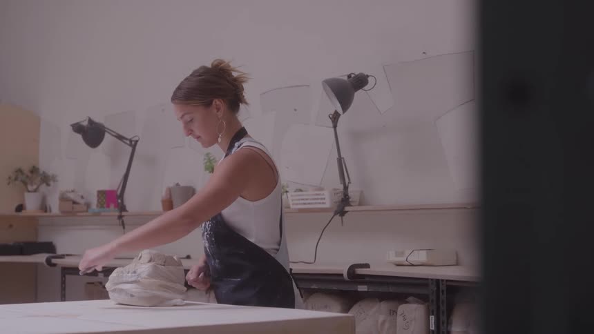 A woman working with clay in a studio