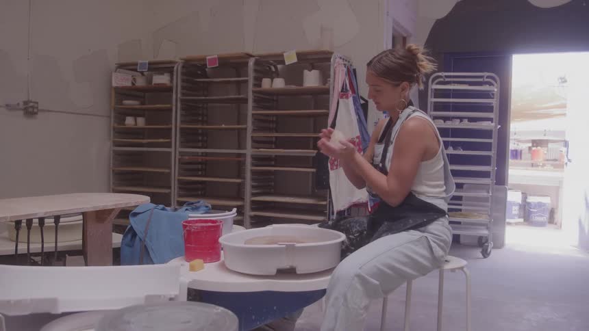 Woman preparing clay with her hands in a pottery studio